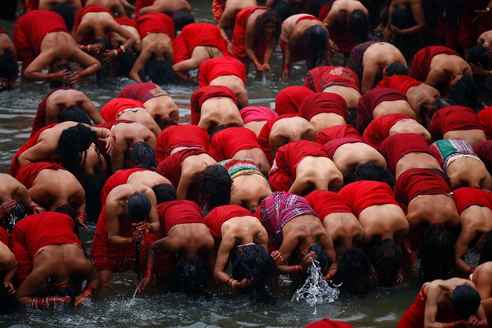 Женщины молятся и купаются в священных водах реки Багмати.