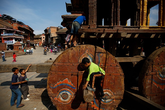 Ребята рассматривают колесницы, на которых перевозят изображения бога Бхайравы и богини Бхадракали.