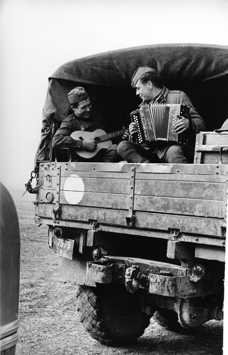 Солдаты играют на инструментах в грузовике.