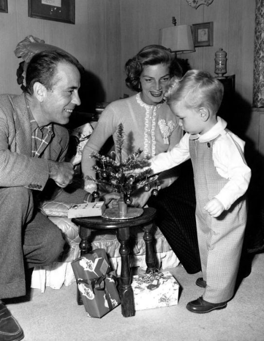 Американский киноактер Хамфри Богарт (Humphrey Bogart) вместе с женой Лорен Бэколли и сыном Стивеном украшают рождественскую елочку.