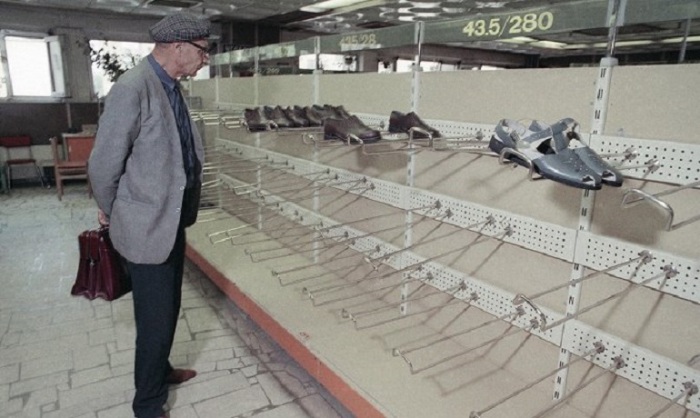 Мужчина разглядывает опустевшие полки обувного отдела в универмаге «Московский», 1990 год.