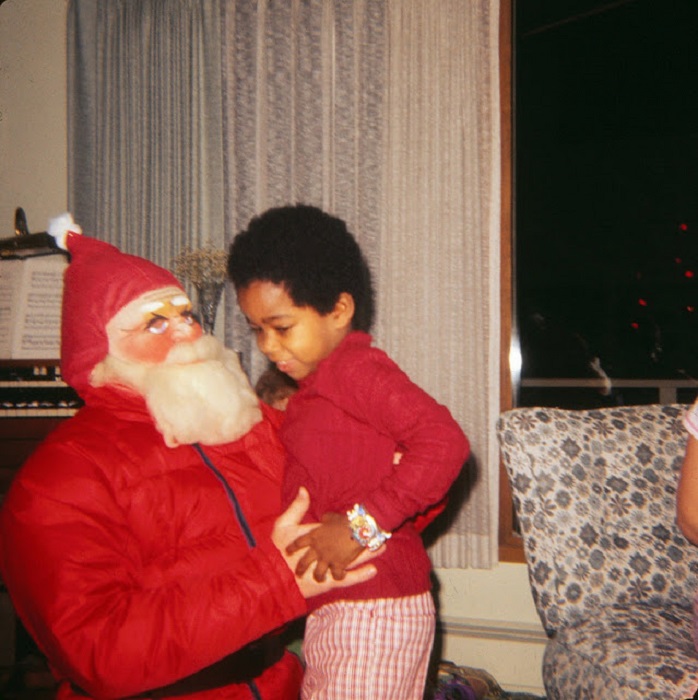 Застенчивый ребенок пытается убежать от Санта-Клауса.