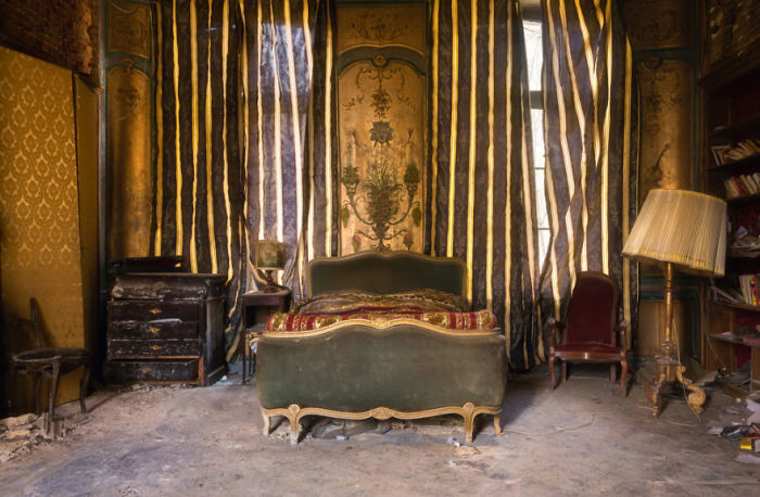 Спальня с сохранившейся антикварной мебелью в заброшенном замке Франции, построенном в 18-м веке.