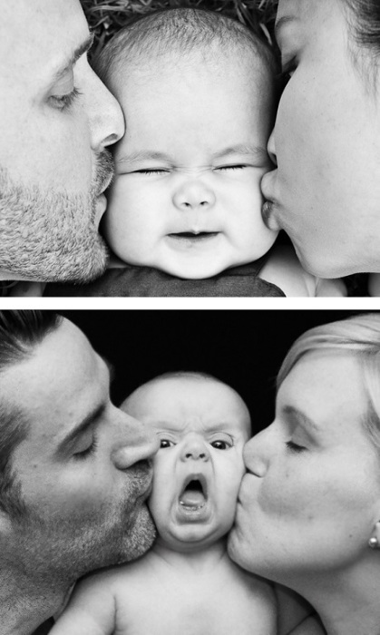 Родители, нежно целующие своего маленького ребёнка.