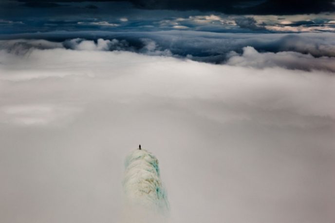 Альпинист Реми МакМертри (Remi McMurtry), стоящий на вершине горы в Исландии.