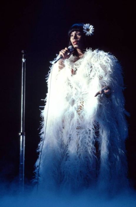 Американская певица Донна Саммер исполняет песню на концерте в плаще из белых перьев в 1979-м году.