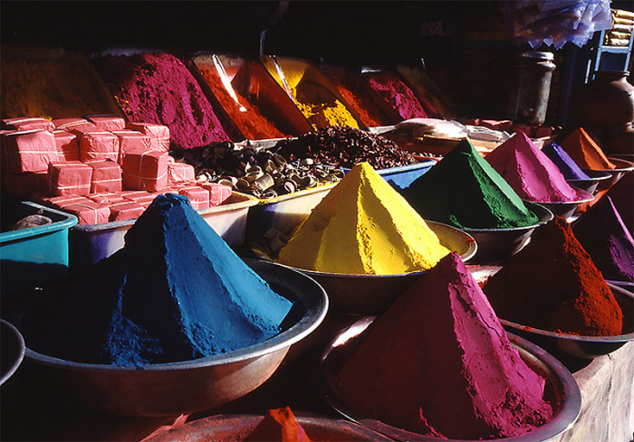 Яркие и разноцветные сухие краски на прилавке магазина в Индии.