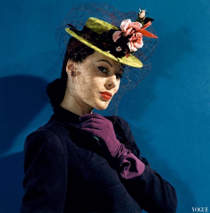 Модель в фетровой шляпе с вуалью и розами, и сиреневых перчатках, Vogue 1941 года.