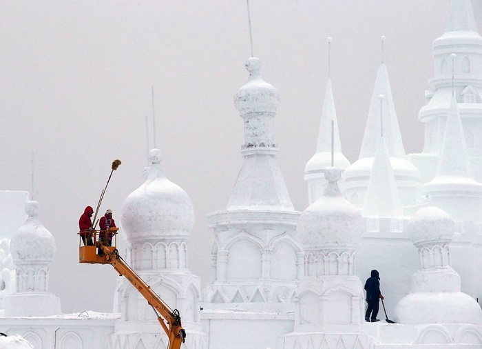 Рабочие полирующие снежную скульптуру.
