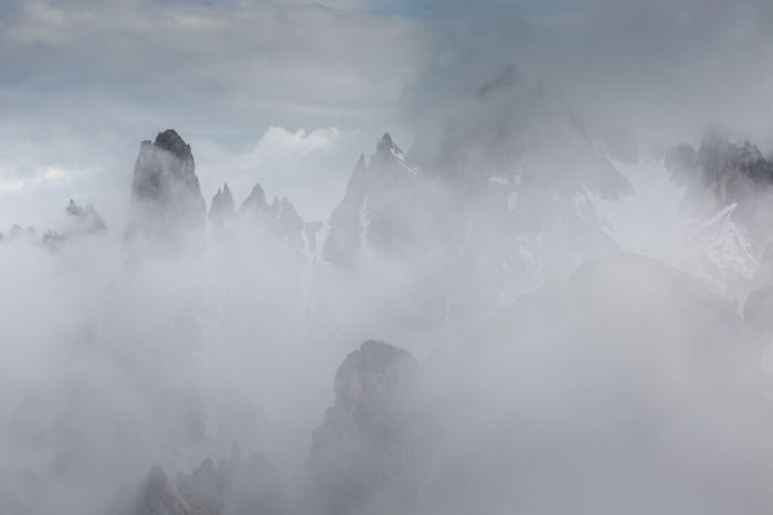 Сквозь густой туман видны только вершины гор.