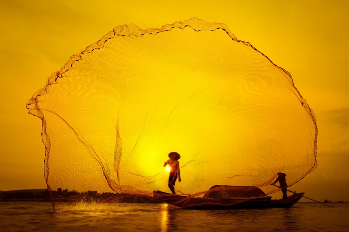 Рыбак закидывает сеть на закате солнца. Фотограф: Туан Нгуйен Манх (Tuan Nguyen Manh).