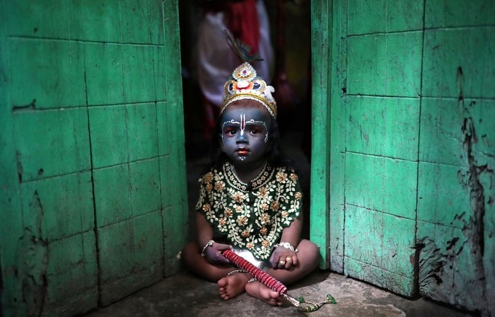Ребенок в костюме бога Кришны во время праздника Джанмаштами (Город Дакка, Бангладеш).