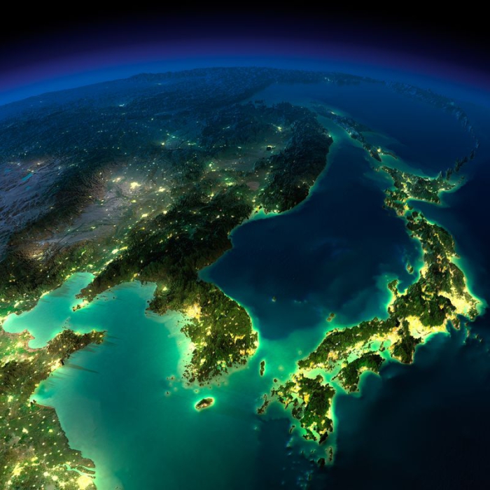 Под ясным небом горят ночные огни Кореи, Японии и Китая.