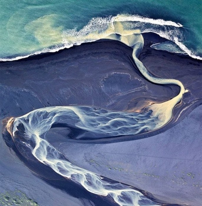 Завораживающий снимок устья реки, сделанный фотографом Андреем Ермолаевым с высоты птичьего полета, превратил обычную фотографию в оптическую иллюзию.