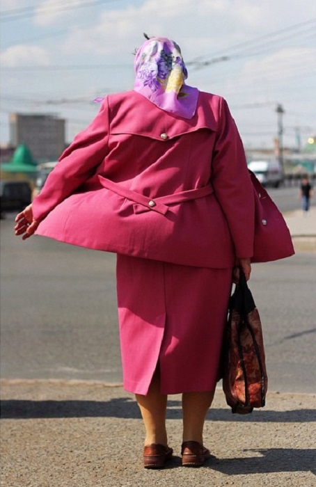 Классический женский костюм дополняет сумка и платочек на голове.