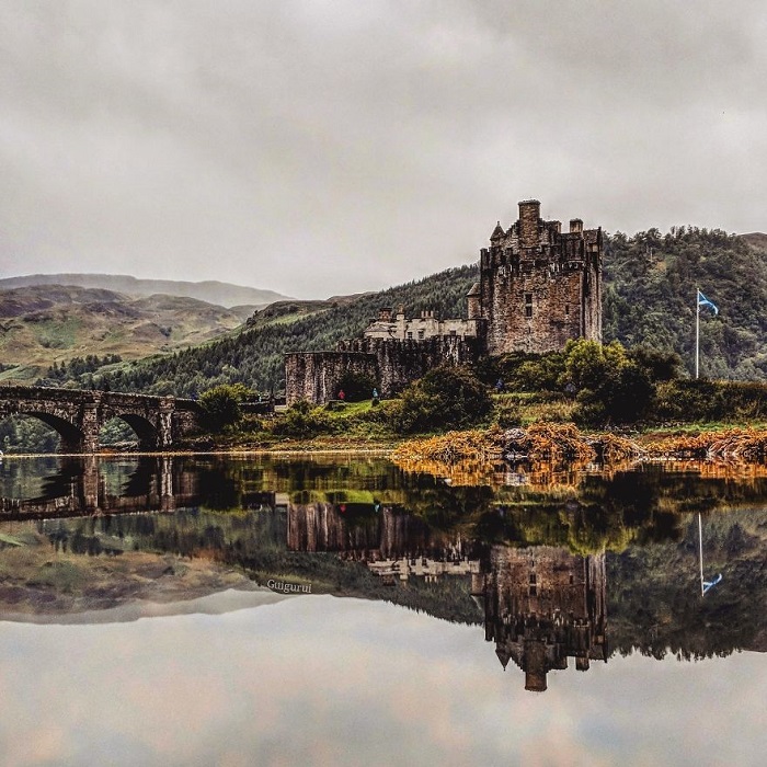 Огромный замок Эйлен-Донан, расположенный в Шотландии, Гвидо Гутьеррес Руис компактно «отразил» в луже, собравшейся на скале после дождя.