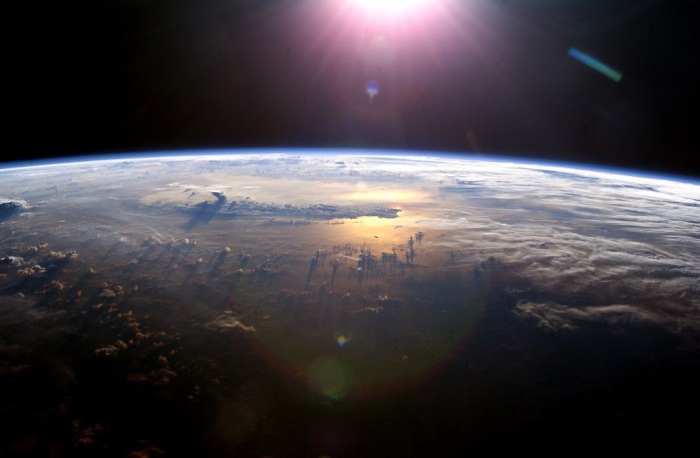 Горизонт Земли в момент, когда солнце садится над Тихим океаном.