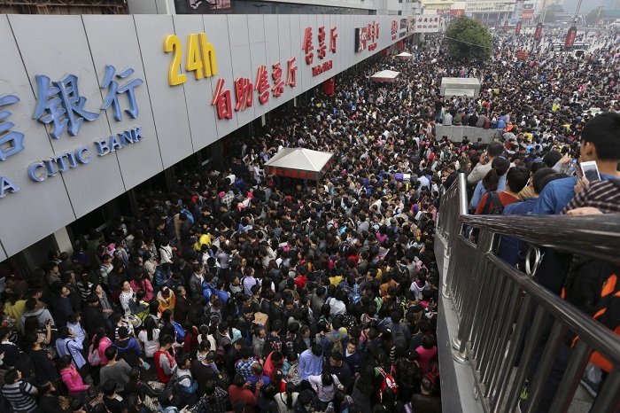 Пассажиры на переполненном железнодорожном вокзале Чжэнчжоу в первый день праздника по случаю годовщины Дня образования КНР.
