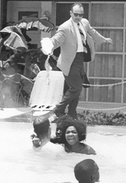 Владелец отеля выливает кислоту в бассейн, в то время как афроамериканцы плавают в нём, 1964 год.