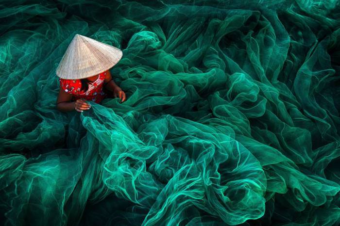 Женщина в небольшой рыбацкой деревушке Фанранг на юге Вьетнама делает традиционную рыболовную сеть. Автор фотографии: Дэнни Йен Вонг Син (Danny Yen Sin Wong).