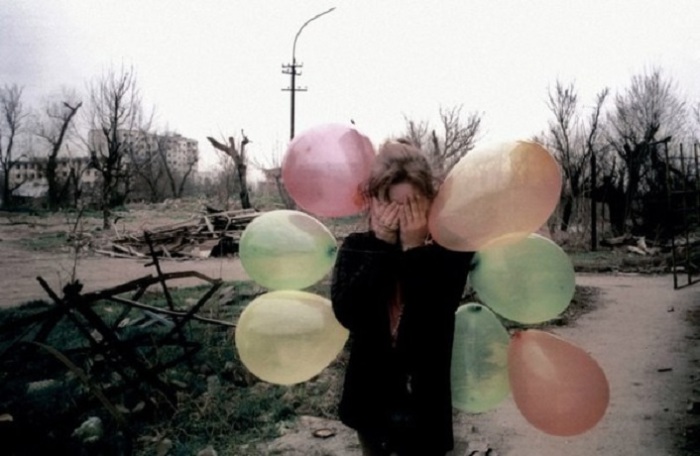 Девочка с цветными воздушными шарами посреди превратившегося в развалины Грозного.