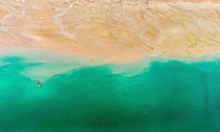Безмятежная бирюзовая вода и золотистый оттенок песка в Дубае.