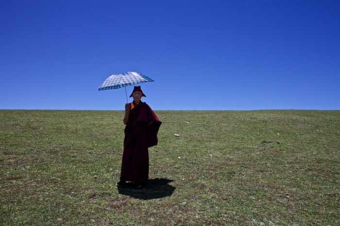 Этот регион славится чрезвычайно изменчивой погодой, поэтому монах предусмотрительно взял с собой зонт, чтобы укрыться от солнца и защититься от дождя.