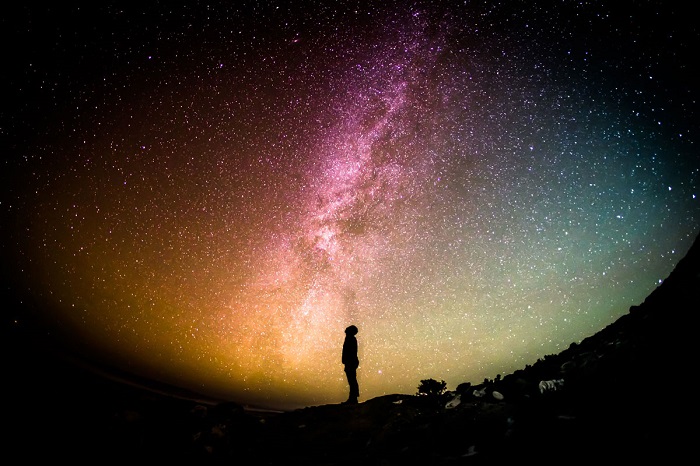 Человек на фоне ярких звезд на ночном небе. Фотограф Greg Rakozy.