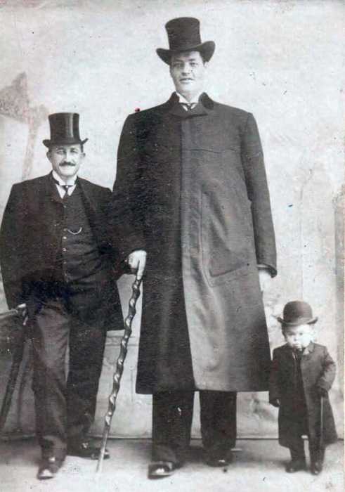 Снимок трех мужчин, которые по высоте отличаются друг от друга разным ростом.