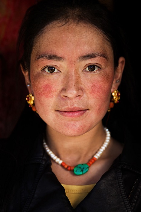 Эта тибетская женщина занималась уборкой в доме, но все же носила украшения.