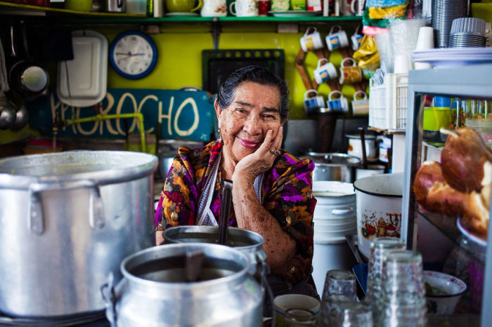 Искренняя улыбка женщины, работающей на продовольственном рынке.