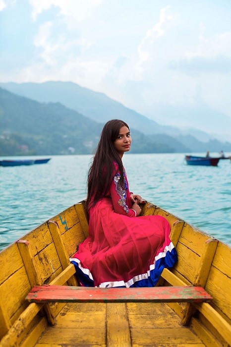 Изящная девушка проводит уик-энд, катаясь на лодке по великолепному озеру Пхева.