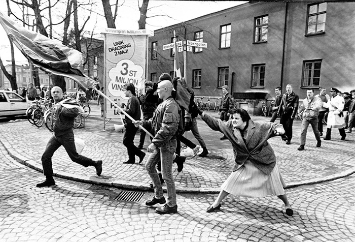 38-летняя Данута Даниельсон бьет сумочкой проходящего нациста-скинхеда Сеппо Селуска во время демонстрации сторонников партии «Nordic Reich».