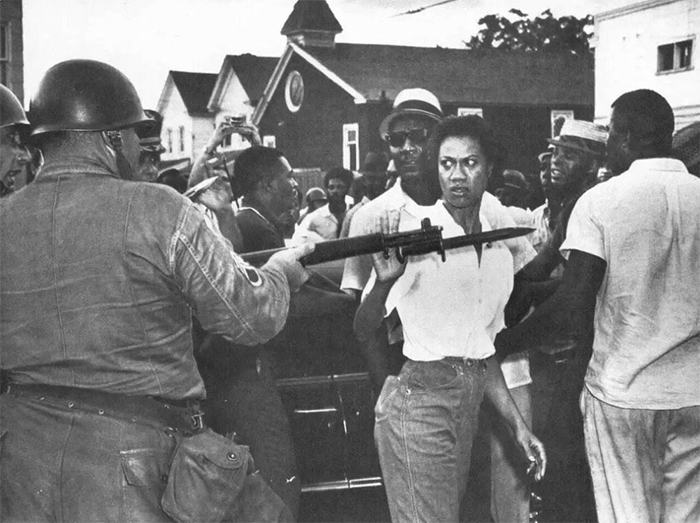 Чернокожая активистка Глория Ричардсон отталкивает направленный на нее штык национального гвардейца во время акции протеста против расового и экономического неравенства.