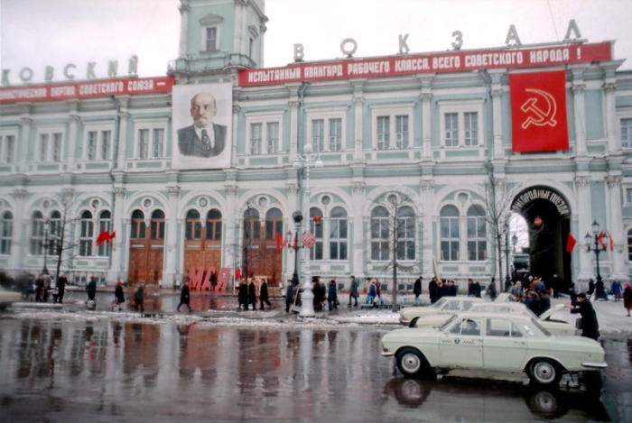 Много красных лозунгов и портрет Ленина.