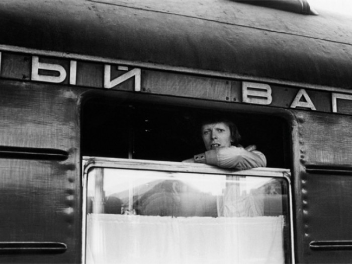 Дэвид Боуи выглядывающий из окна вагона во время путешествия по Транссибу.
