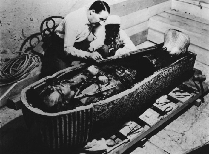 Археолог Говард Картер исследует саркофаг, найденный в гробнице Тутанхамона. 