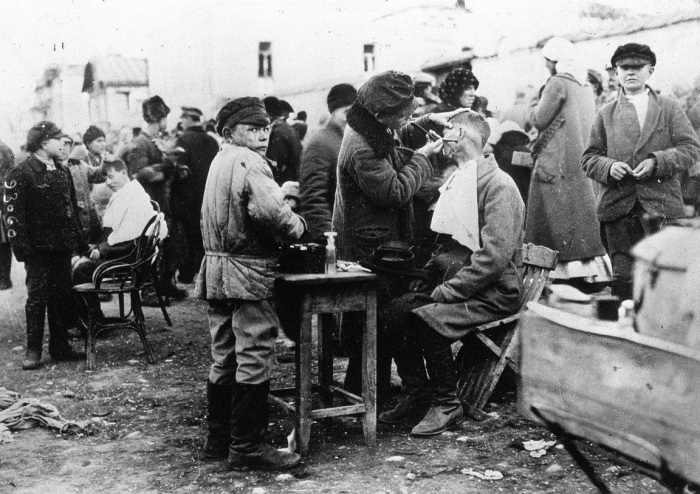 Дети, подрабатывающие на уличной парикмахерской в Советской России.