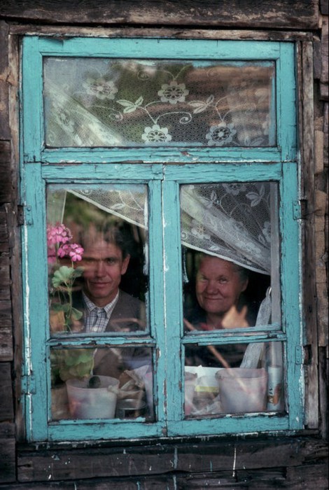 Молодой человек со своей мамой смотрящие в окно. СССР, Сибирь, 1991 год.