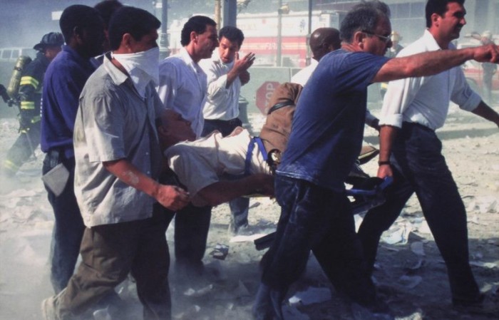 Люди, несущие раненого вовремя теракта в Нью-Йорке. США, 11 сентября 2001 года. Фото: Bill Biggart.