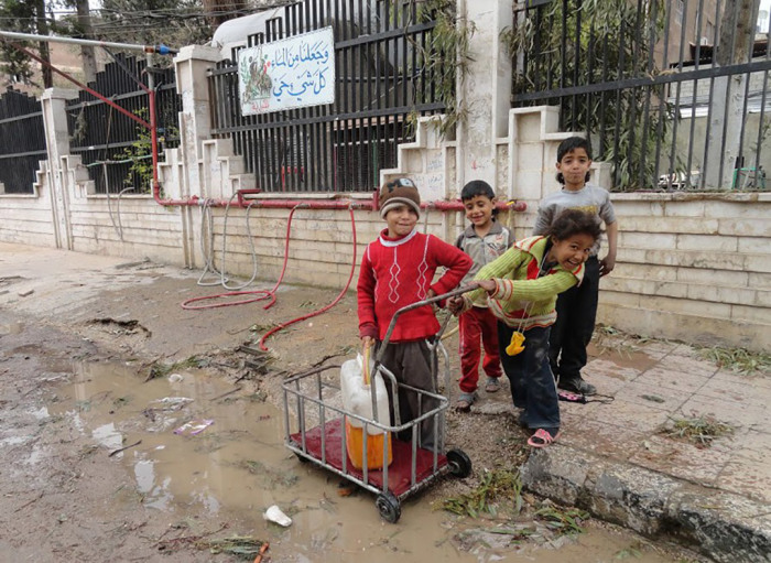 Дети набирают грязную воду в канистру в лагере палестинских беженцев.