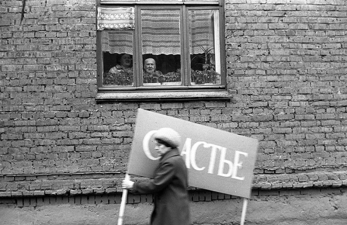 Женщина с плакатом спешит на первомайскую демонстрацию. СССР, Новокузнецк, 1 мая 1983 года.