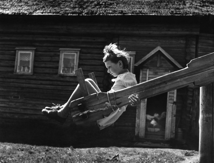 Девочка катается на качелях во дворе. СССР, Подмосковье, 1977 год.