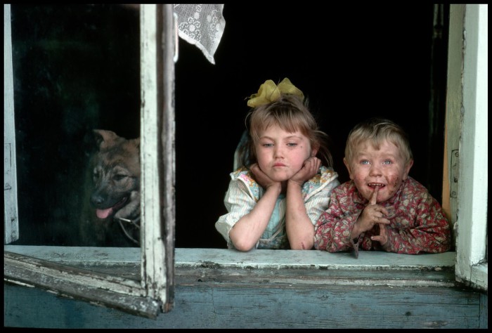 Дети, выглядывающие из окна. СССР, Новокузнецк, 1991 год.