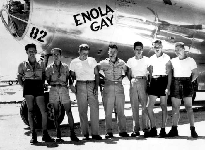 Экипаж американского бомбардировщика Б-29 Enola Gay позирует возле своего самолета.