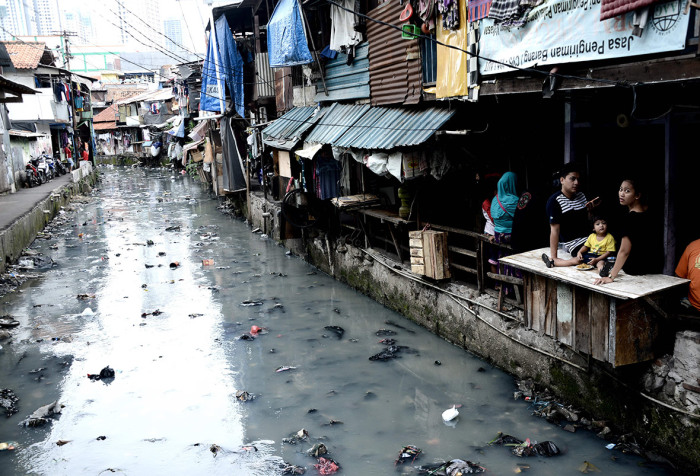 Загрязнённый канал в трущобах Джакарты.