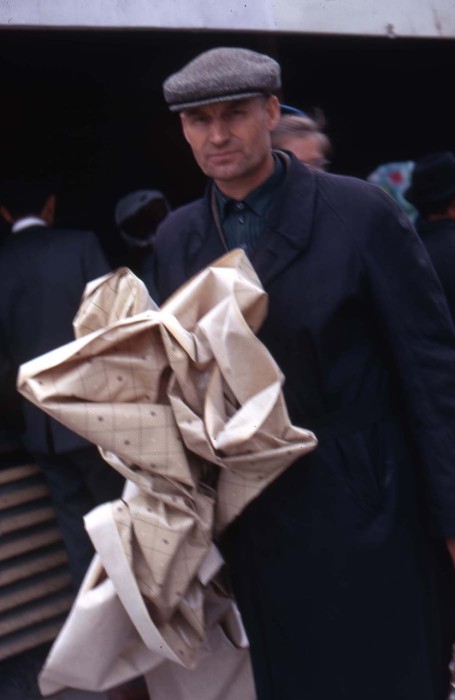 Мужчина только что купивший за 25 копеек кусок клеенки. СССР, Новосибирск, 1969 год.