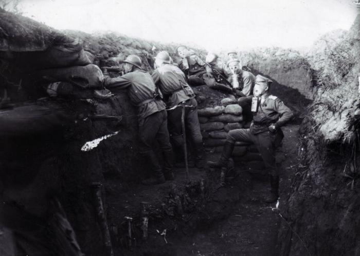 Чешские войска в противогазах сидящие в окопах.