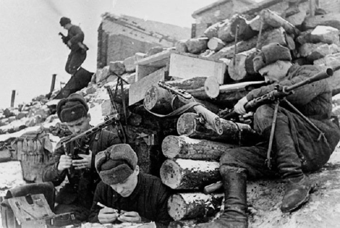 Красноармейцы у землянки в Сталинграде чистят оружие.