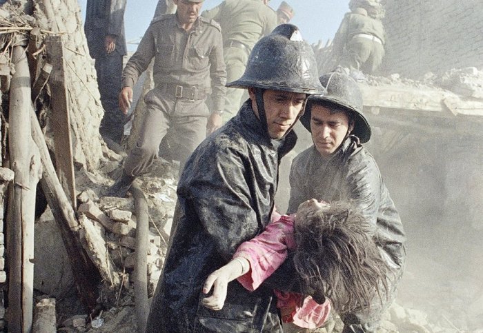 Афганские пожарные и девочка, погибшая в результате мощного взрыва в центре Кабула, 14 мая 1988. 